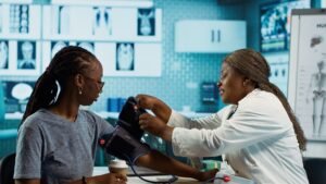 black medic practitioner takes blood pressure with a blood pressure monitor